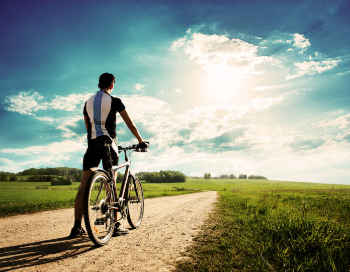 Rear,View,Of,A,Young,Man,With,Bicycle,On,Summer treino de base